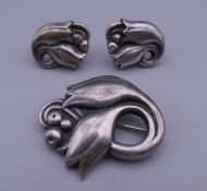 A Georg Jensen silver brooch and earrings. The former 3.5 cm wide.