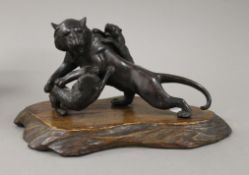 A small Japanese bronze animalier group formed as a tiger and wolves. 20 cm long.