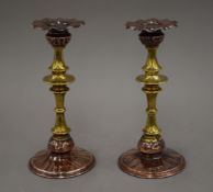 A pair of Art Nouveau copper and brass candlesticks and a round copper tray.