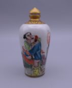 A Chinese porcelain snuff bottle depicting an erotic scene. 9 cm high.