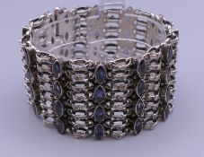 A silver bracelet set with blue stones. 17 cm long.