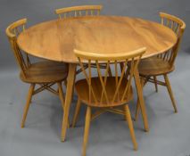 A blonde Ercol table and chairs. The table 112 cm long.