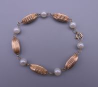A 14 K gold and pearl bracelet. 17 cm long. 4.9 grammes total weight.