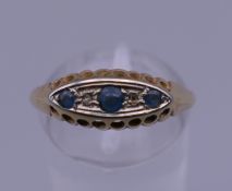An 18 ct gold diamond and sapphire ring. Ring size Q. 2 grammes total weight.