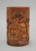 A 19th century Chinese bamboo brush pot of typical form, carved with figures at play. 13.5 cm high.