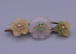 An 18 kt gold diamond set rock crystal flower brooch. 7 cm wide. 16.8 grammes total weight.