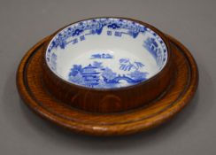 A small blue and white porcelain butter dish on oak stand. 15.5 cm diameter.