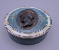 An agate mounted enamel decorated silver box. 9 cm diameter. 6.1 troy ounces total weight.