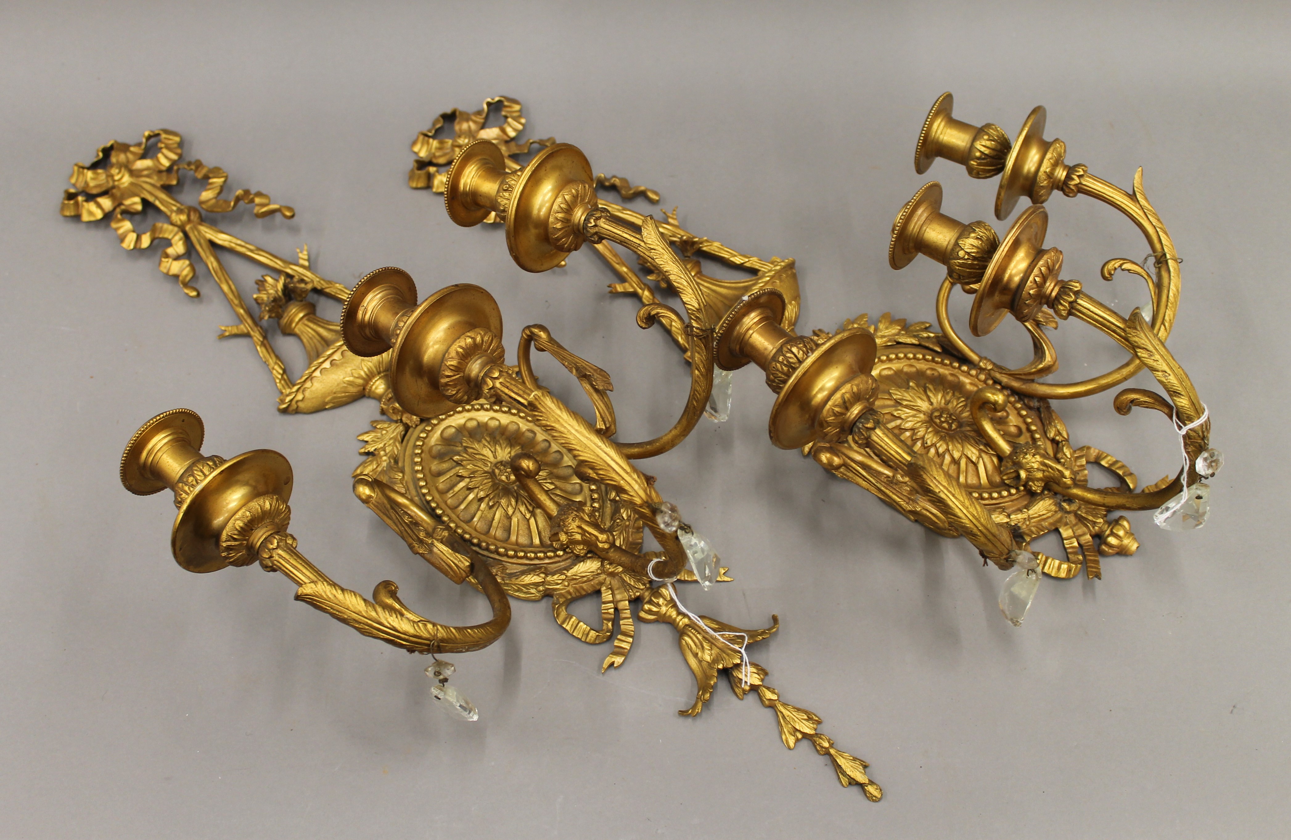 A pair of ormolu three-branch wall lights. 68 cm high.