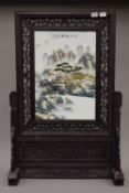 A Chinese porcelain screen on wooden stand. 67.5 cm high.