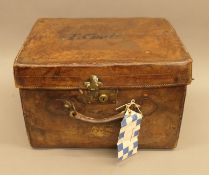 A leather hat box, stamped T Coats, with two top hats inside,