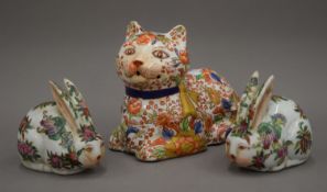 An Oriental porcelain model of a cat and two rabbits. The former 19 cm long.
