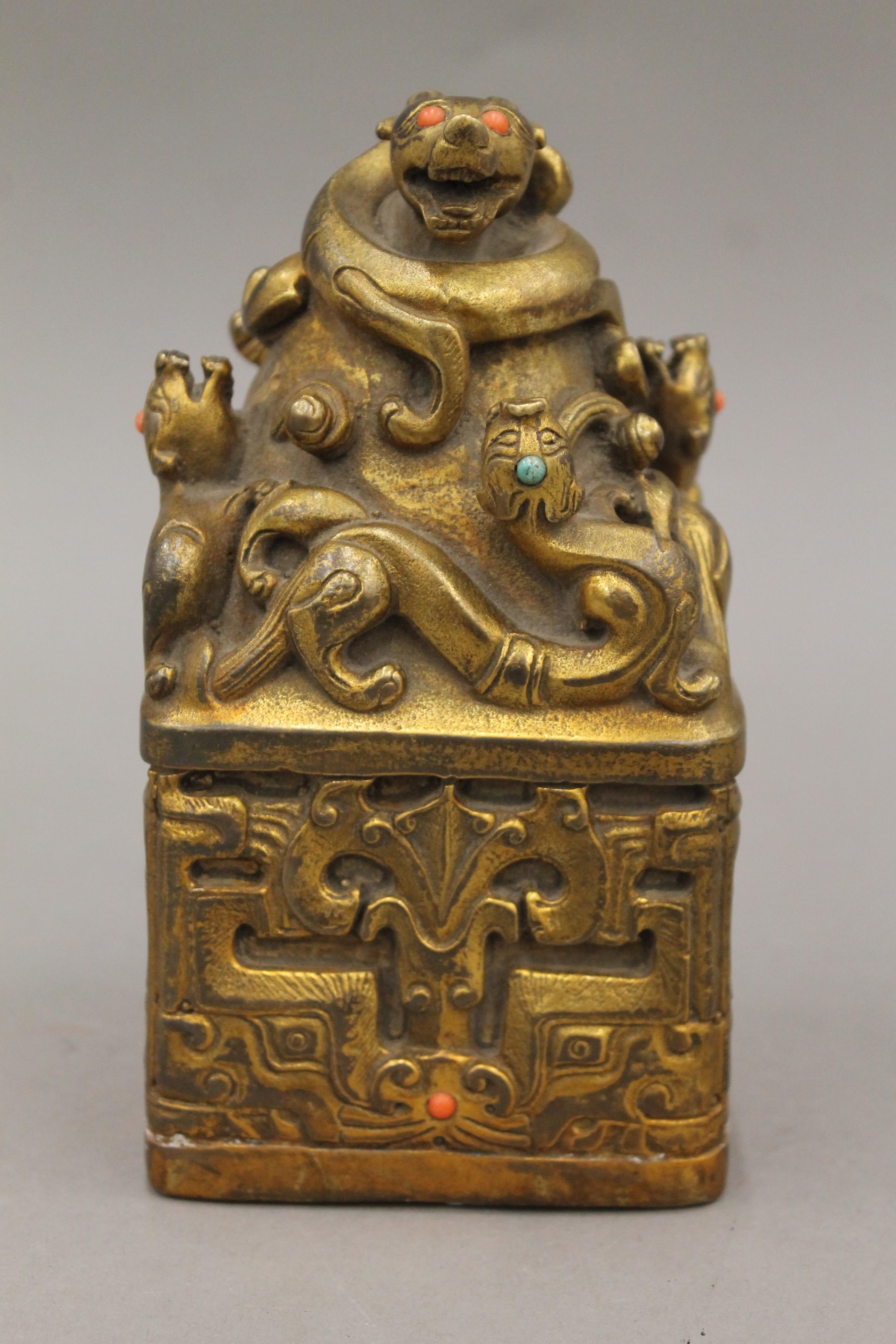 A large Chinese gilded bronze square seal with turquoise and red coral stones. 16.5 cm high.