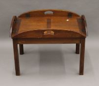 A mahogany butlers tray type coffee table. 86 cm long with flaps down.