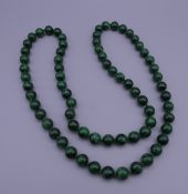 A string of malachite beads. 80 cm long.