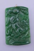 A gold mounted jade pendant. 6.5 cm high.