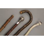 A bamboo cane swagger stick, a silver topped walking stick and two other sticks.