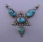 A silver and turquoise pendant. 6 cm wide.