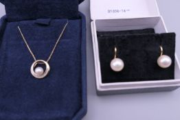 A pair of single pearl earrings with 9 ct gold mounts and a 9 ct gold pearl pendant on a 9 ct gold