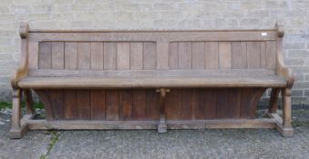 A Victorian Arts and Crafts carved oak pew. 216 cm long.