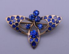 An Art Deco style blue enamel and blue stone set brooch. 3.5 cm wide.