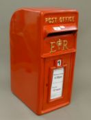 A red painted post box. 57 cm high.