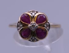 A 9 ct gold ruby and diamond flower ring. Ring size M.