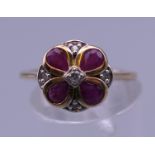 A 9 ct gold ruby and diamond flower ring. Ring size M.