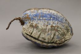 A painted and posted coconut husk set with a postage stamp. 27 cm long.