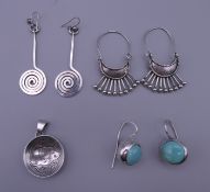 Three pairs of silver earrings and a Native American silver pendant.