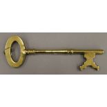 A large brass key. 35 cm long.