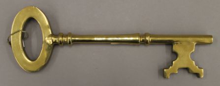 A large brass key. 35 cm long.