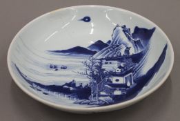 A 19th century Chinese porcelain dish painted with figures in a mountainous landscape.