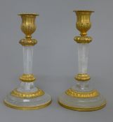 A pair of gilt bronze and rock crystal candlesticks. 18 cm high.