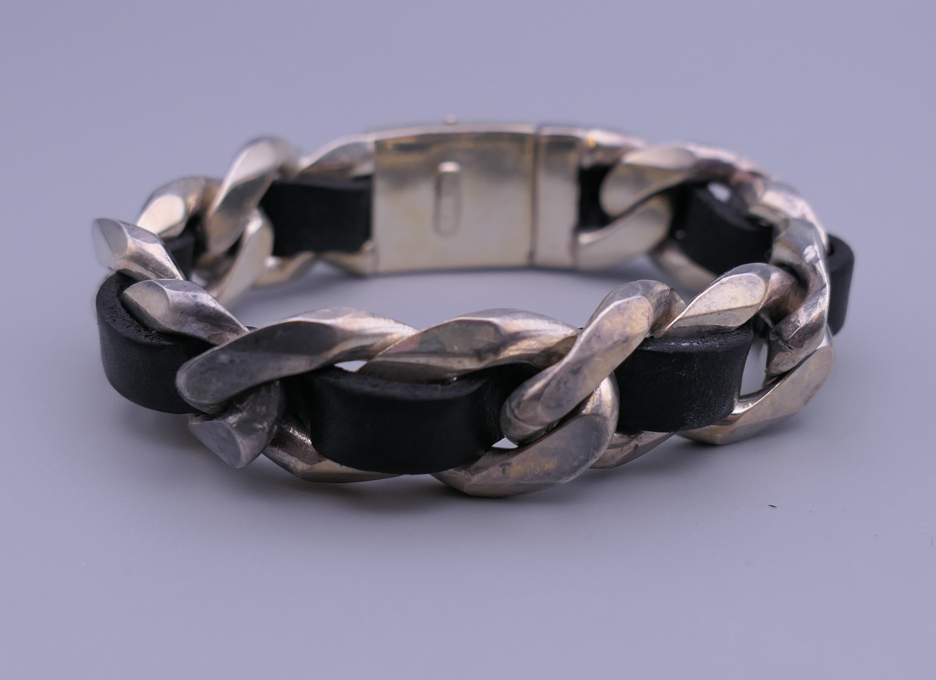 A silver and black leather bracelet.