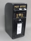 A black painted post box. 57 cm high.