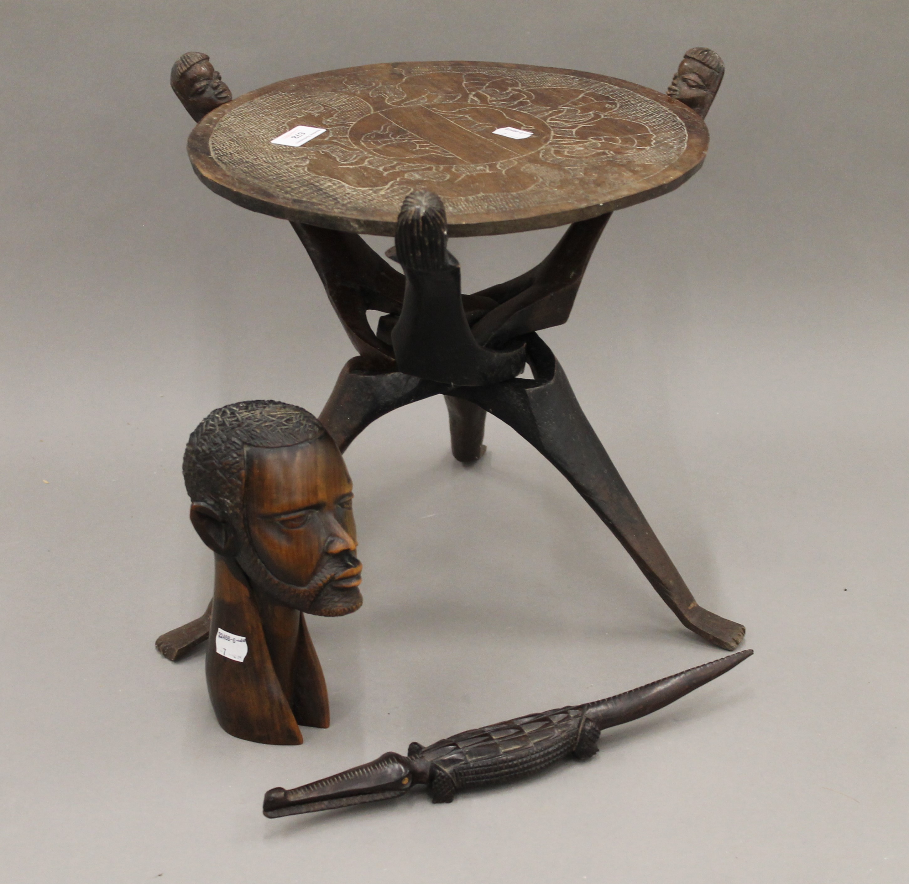 An African carved table, a male bust and a crocodile. The former 36.5 cm high.