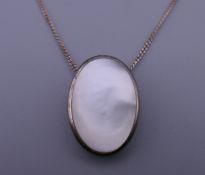 A silver and mother-of-pearl pendant on a silver chain. The pendant 2 cm high.