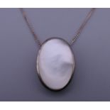 A silver and mother-of-pearl pendant on a silver chain. The pendant 2 cm high.