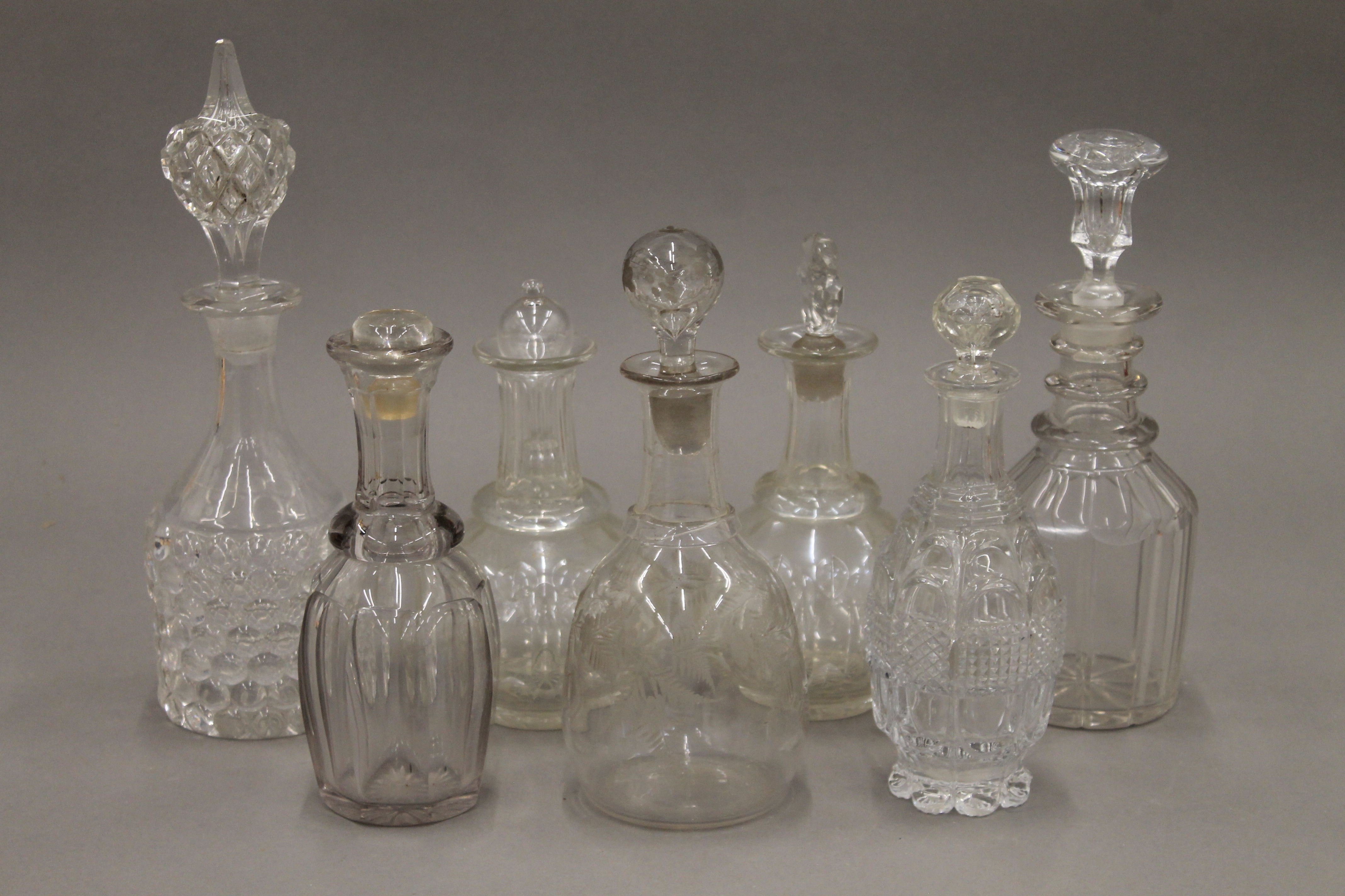A quantity of various cut glass decanters.