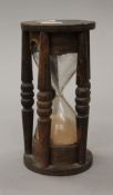 An antique rustic hourglass timer. 18.5 cm high.