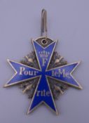 A cross form medal with enamel decoration. 5.5 cm high.