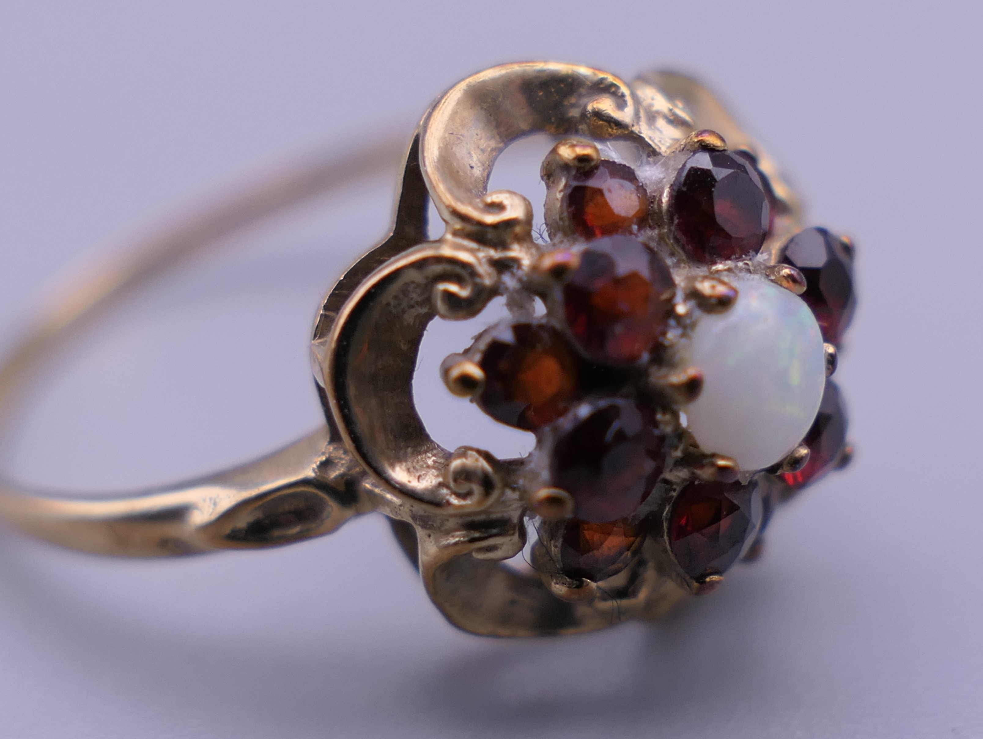 An unmarked 9 ct gold garnet and opal ring. Ring size M. 1.6 grammes total weight. - Image 4 of 4