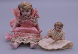 Two Victorian miniature bisque dolls in original dresses. The largest 9.5 cm high.