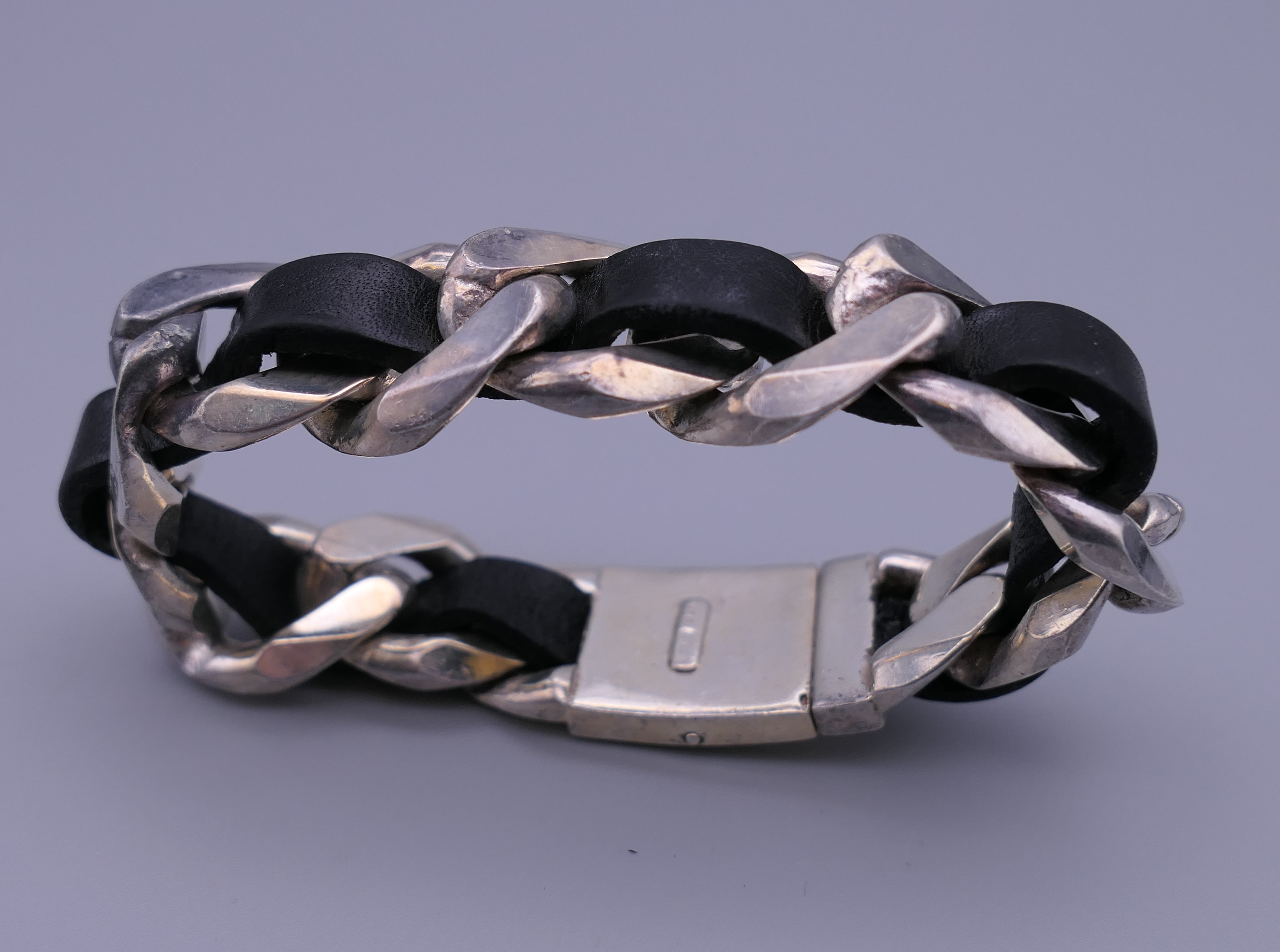 A silver and black leather bracelet. - Image 2 of 4