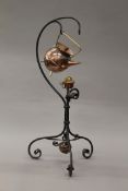 A Christopher Dresser for Benham and Froud Arts and Crafts copper kettle on a wrought iron stand.