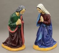 A vintage painted plaster nativity set comprising Mary, Joseph, the Baby Jesus and a bull.