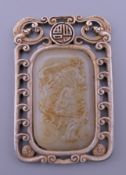 An unmarked white metal and jade pendant. 5.5 cm high.