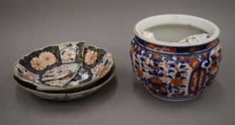 A 19th century Imari vase and two 18th century Imari plates. The former 16 cm high.
