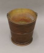 A 19th century brass lined ribbed wooden bucket. 31 cm high.